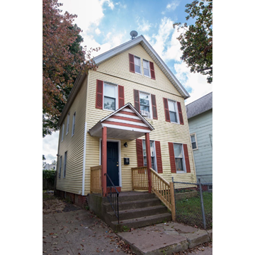 New Haven apartment for rent - A yellow house with red shutters and a black door.