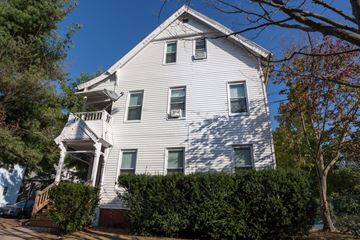 New Haven apartment for rent - A white house with a porch and a tree in front.