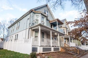 New Haven apartment for rent - A two story house with a white fence in front.