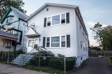 New Haven apartment for rent - A white house with a green roof and a fence in front.