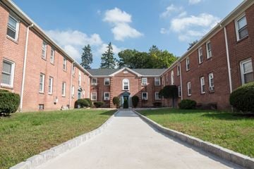 New Haven apartment for rent - A long brick building with a green lawn in front.