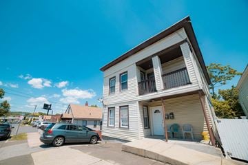 West Haven apartment for rent - A two-story house with a car parked in front.