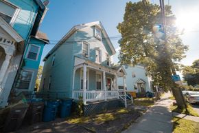 New Haven apartment for rent - A blue house with a white porch and a tree in front.