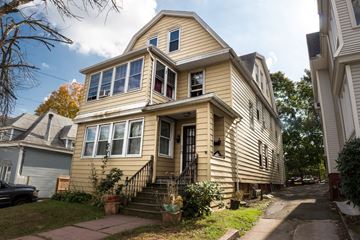 New Haven apartment for rent - A two-story house with a front porch and a car parked in the driveway.