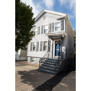 Andover apartment for rent - A two-story house with a blue door and a black metal railing on the stairs.