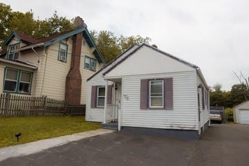 New Haven apartment for rent - A white house with a red door is in front of a brick house.