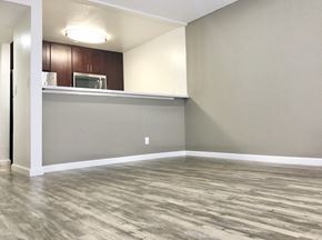 Hollywood apartment for rent - an empty living room with wood flooring and a kitchen