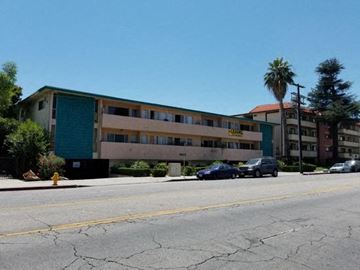 Van Nuys apartment for rent - a large building with cars parked in front of it