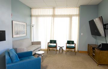 Boston apartment for rent - a living room with a couch and chairs and a television