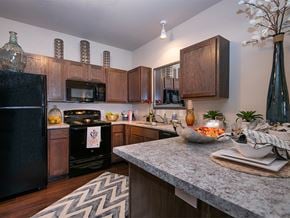 Derby apartment for rent - a kitchen with a granite counter top and a black refrigerator