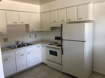 Lansing apartment for rent - A white kitchen with a sink, stove, and refrigerator.