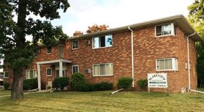 Lansing apartment for rent - A brick house with a sign in front of it.