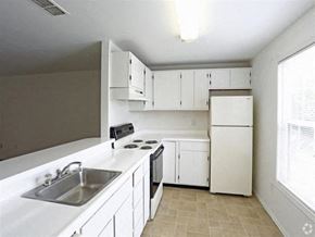 Monroe townhouse for rent - a kitchen with white cabinets and a sink
