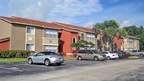 Deerfield Beach apartment for rent - a parking lot with cars in front of an apartment building