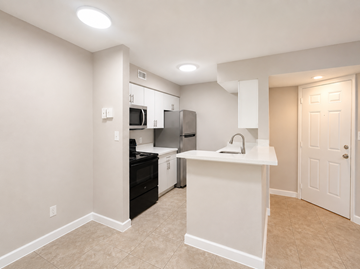 Deerfield Beach apartment for rent - A kitchen with white cabinets and appliances.