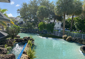 Deerfield Beach apartment for rent - a lazy river with palm trees and houses in the background