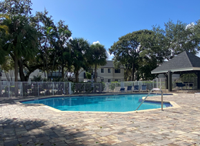 Deerfield Beach apartment for rent - a pool with a fence around it and a building in the background