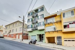 San Francisco apartment for rent - A motorcycle is parked on the sidewalk in front of a yellow building.