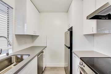 San Francisco apartment for rent - A kitchen with white cabinets and a black refrigerator.