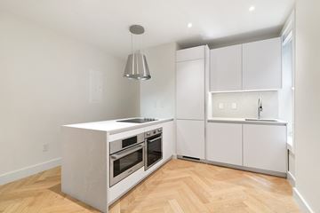 Manhattan apartment for rent - a renovated kitchen with white cabinets and stainless steel appliances