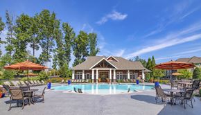 Richmond apartment for rent - a swimming pool with chairs and umbrellas in front of a house