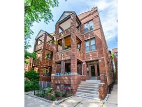 Chicago apartment for rent - A red brick building with a black iron fence in front.