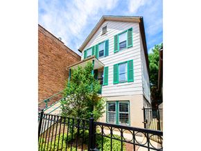 Chicago apartment for rent - A house with green shutters and a black fence.