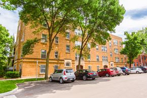 Chicago apartment for rent - a large brick building with cars parked in front of it