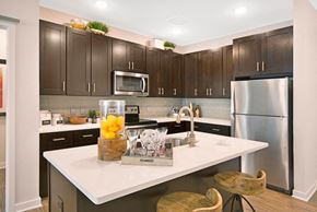 Sewell apartment for rent - a kitchen with stainless steel appliances and dark cabinetry