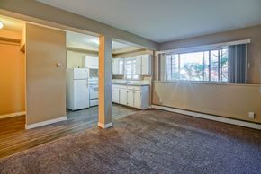 Calgary apartment for rent - an empty living room with a kitchen and a window