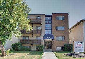 Calgary apartment for rent - an apartment building with a sidewalk and a sign in front