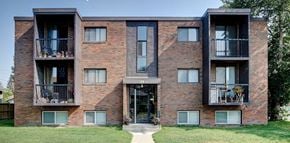 High River apartment for rent - a brick apartment building with balconies and a sidewalk