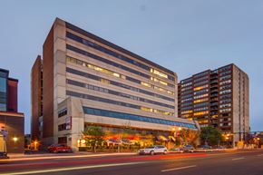 Calgary apartment for rent - an evening view of an office building on a city street