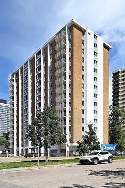 Edmonton apartment for rent - A white and brown building with a tree in front of it.