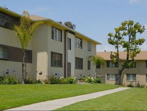 Los Angeles apartment for rent - A row of beige apartment buildings with green lawns in front.
