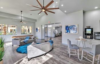 Resident clubhouse with lounge seating, tvs, shuffle board, kitchen area & fireplace