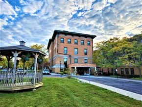 Canandaigua apartment for rent - a large brick building with a gazebo and a cloudy sky