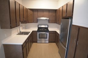 Northampton apartment for rent - an empty kitchen with wooden cabinets and stainless steel appliances