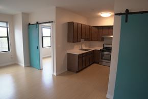 Northampton apartment for rent - an empty kitchen with wood flooring and a blue sliding door