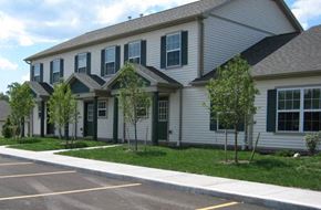 Farmington townhouse for rent - A white building with green shutters and a grey roof.