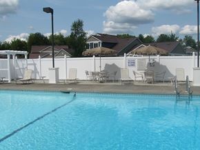 Jamestown apartment for rent - a swimming pool with chairs and tables next to a white fence