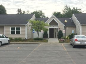 Rushville apartment for rent - a house with a parking lot and cars in front of it