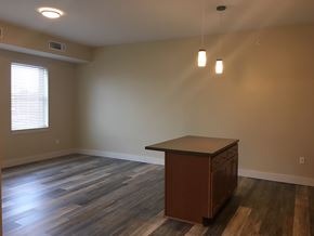 Rochester apartment for rent - an empty living room with a desk and a window