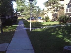 Mahwah apartment for rent - A sidewalk with a lamp post and a tree in the background.