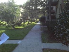 Mahwah apartment for rent - A residential street with a white sign on the sidewalk.
