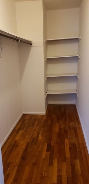 River Vale apartment for rent - Empty room with white shelves and wooden floor.