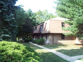 River Vale apartment for rent - A house with a brown roof and a white chair in front of it.