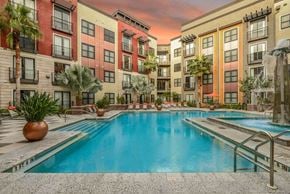 St. Petersburg apartment for rent - A large swimming pool in front of a multi-story apartment building.
