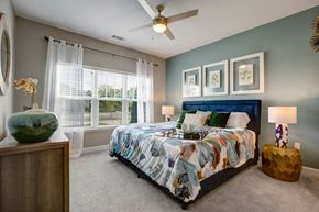 Charlotte apartment for rent - Bedroom. Big bed with two nightstands, light carpet, dresser, big windows, and ceiling fan at Ascent at Mallard Creek Charlotte, NC