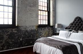 Philadelphia apartment for rent - A bedroom with a large bed and a brick wall.